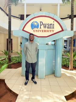 Image of me posing for a photo during our visit to Pwani University, Kenya