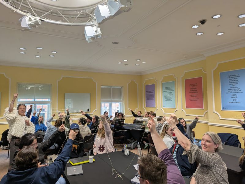 Attendees raising their hands during a session at the SCDTP Cumberland Lodge residential